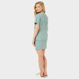 Bluza medyczna Aria w kolorze Sage Green, widok tyłem na kobiecie.