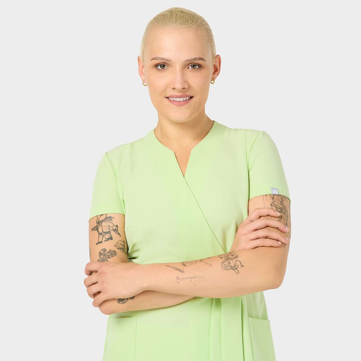 Fartuszek medyczny Matcha SOPHIA z przodu: Przedstawienie fartuszka medycznego w modnym kolorze Matcha, widzianego z przodu. Idealny wybór dla profesjonalistek w branży medycznej i kosmetycznej.